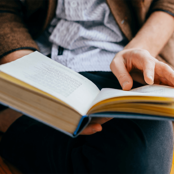 Hands holding an open hardcover book