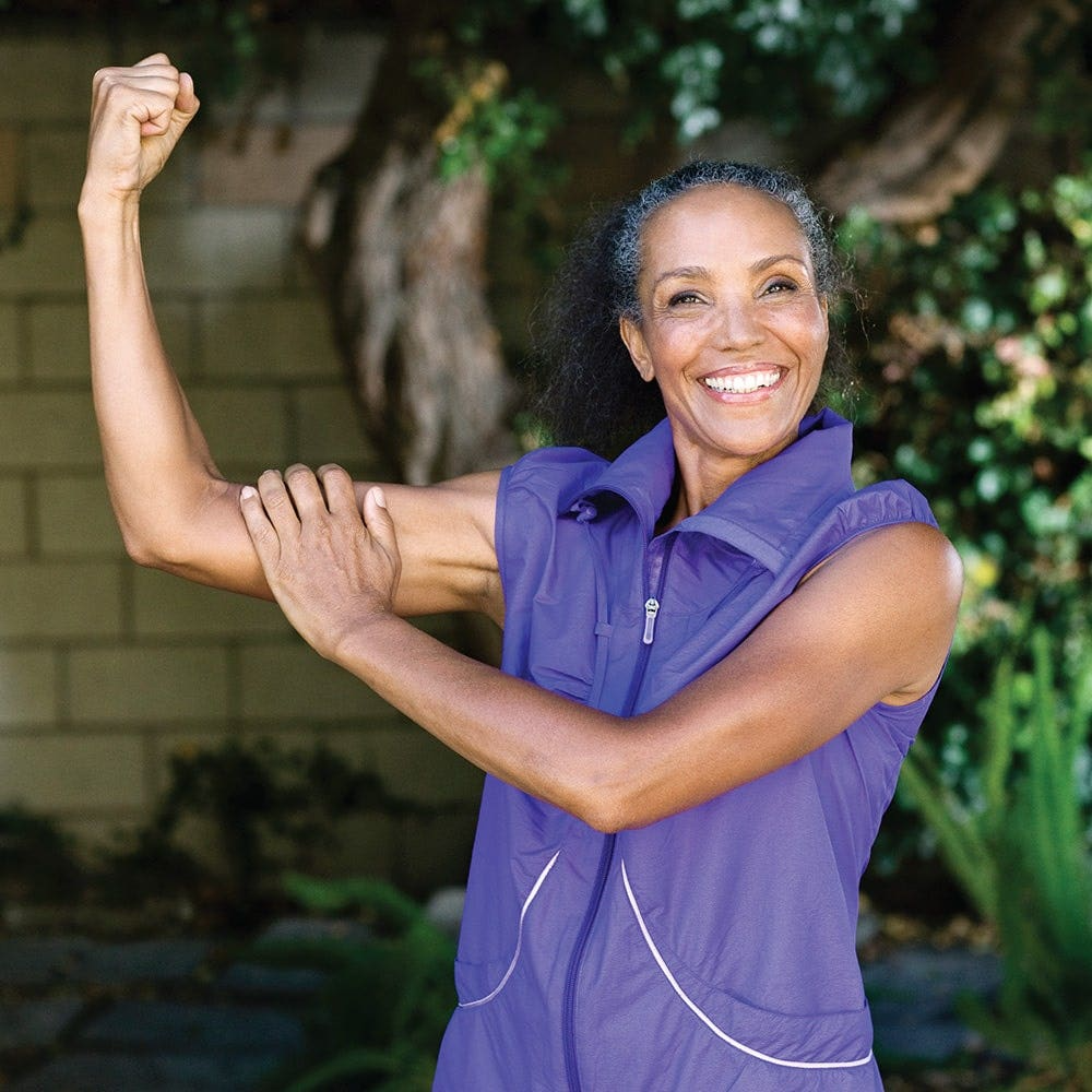 Woman showing her arm muscle and smiling