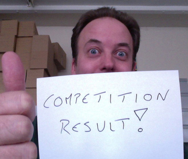 Paul Spragg holding up the words "competition result!"