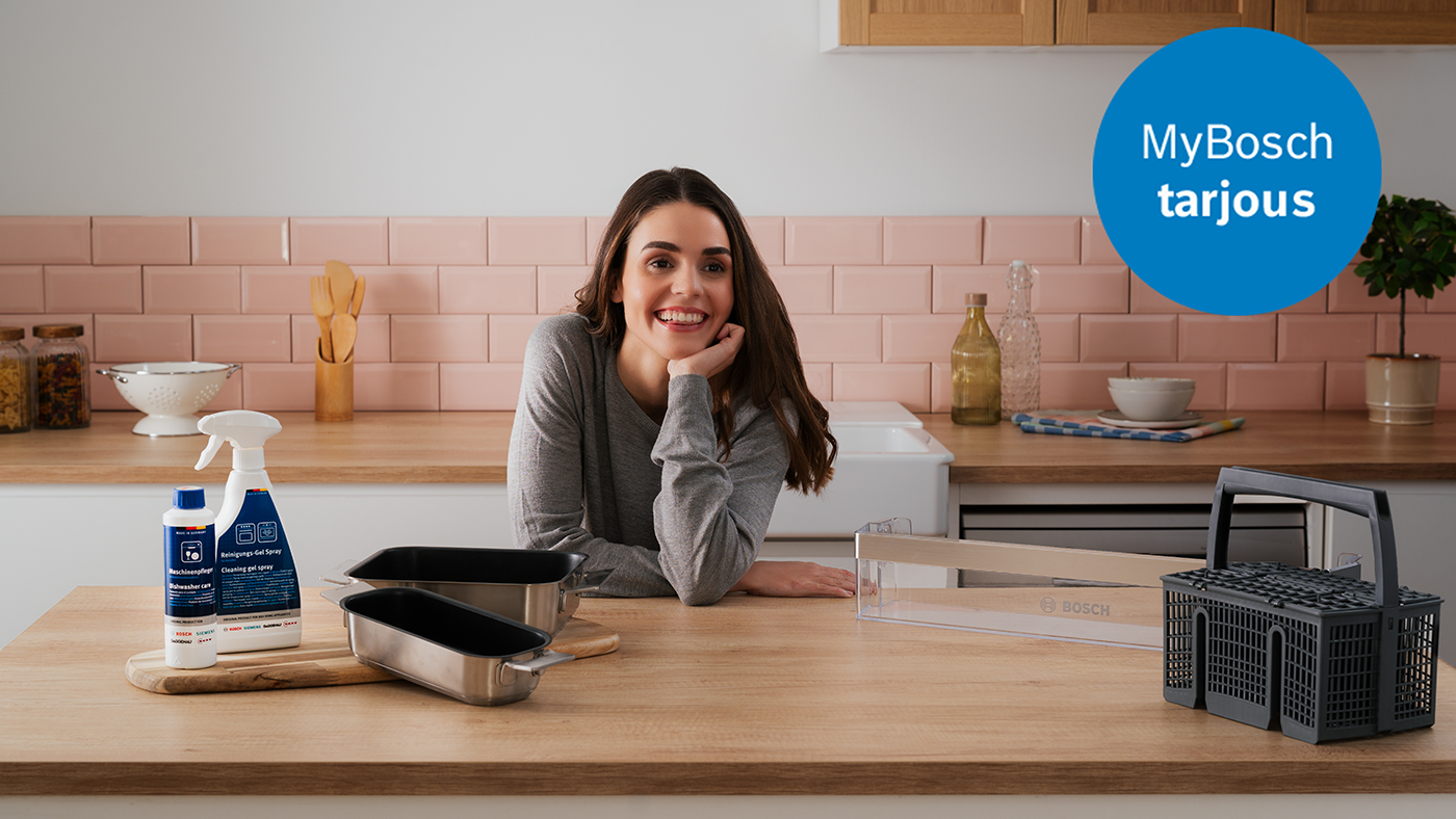 Keitti&ouml;n tasolla Boschin astianpesupuhdistusaineet, kaksi vuokaa ja astianpesukori, taustalla vaaleanpunaiset laatat ja keitti&ouml;v&auml;lineit&auml;.