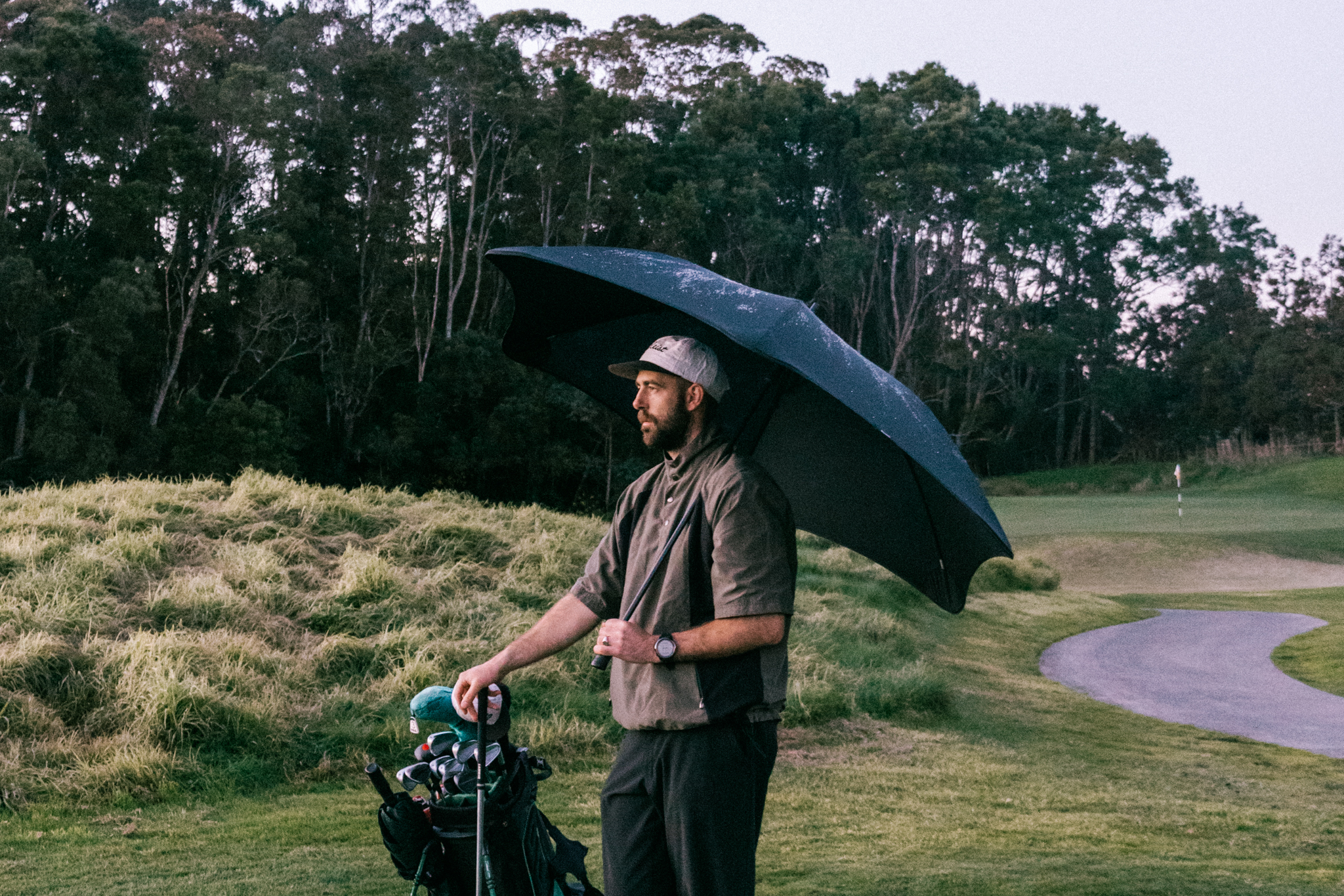 Man with Blunt Sport umbrella on the golf course