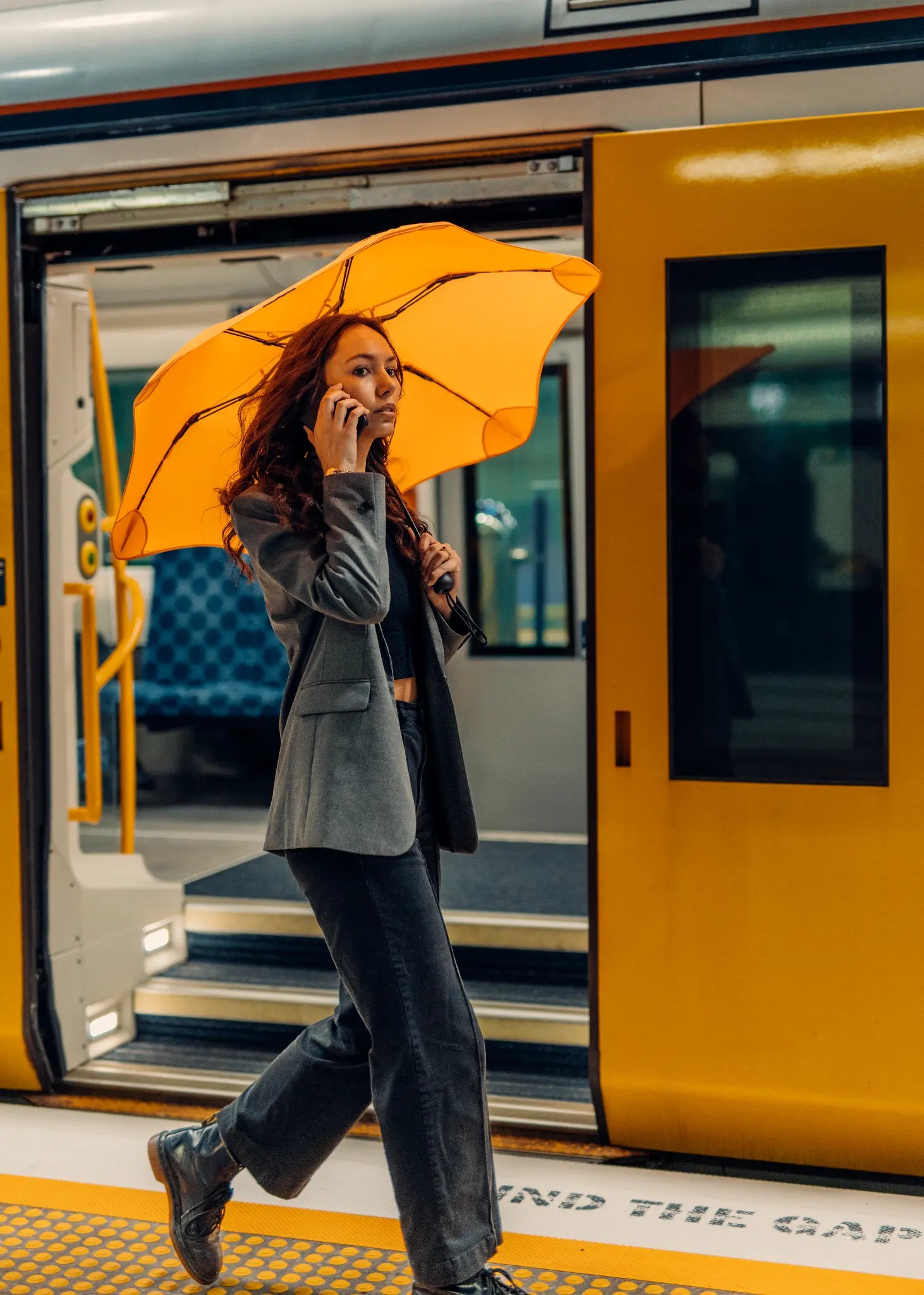 Woman with Blunt Metro umbrella in Mango Orange