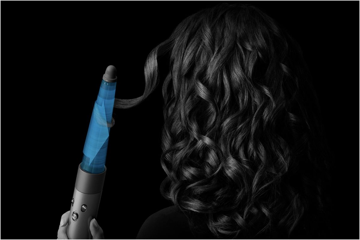 Model curling hair with the conical barrel attachment.