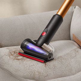 El minicepillo motorizado antienredos 2.0 se utiliza para limpiar una silla.