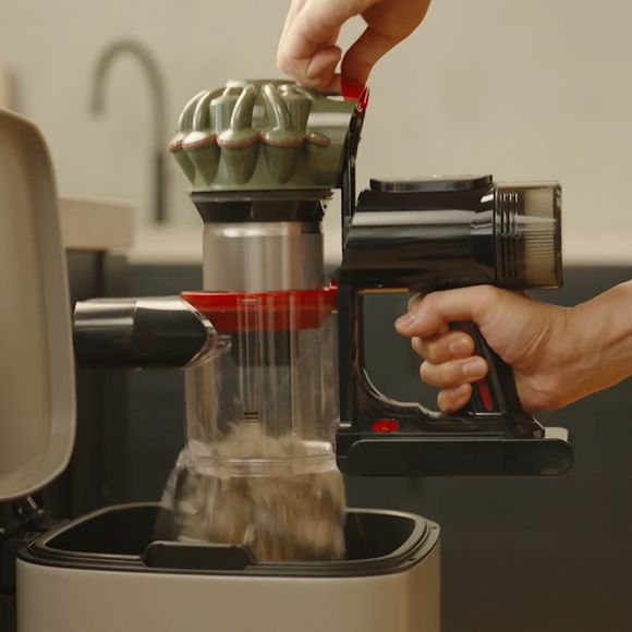 La aspiradora sin cable Dyson V8 Cyclone se vacía en un cubo de basura doméstico.