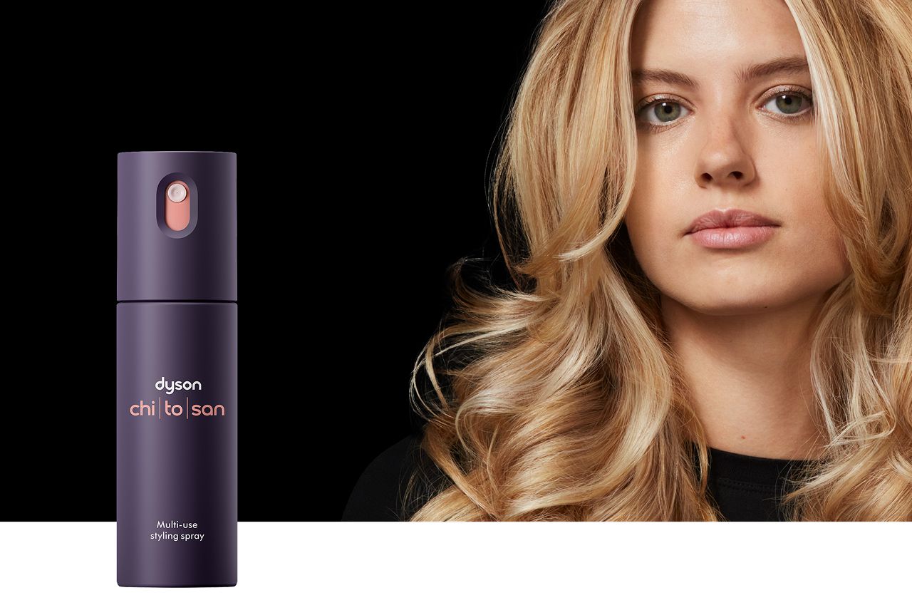 Modelo con cabello moldeado detrás del spray de peinado multiusos Dyson Chitosan.