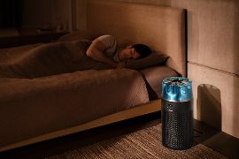 El purificador Dyson HushJet Compact en funcionamiento en un dormitorio junto a una persona dormida.