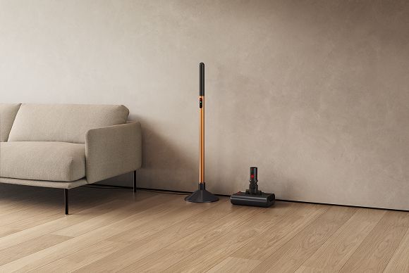 El tubo de la fregona eléctrica Dyson PencilWash colocado en su base de carga, con el cabezal en la bandeja de goteo.