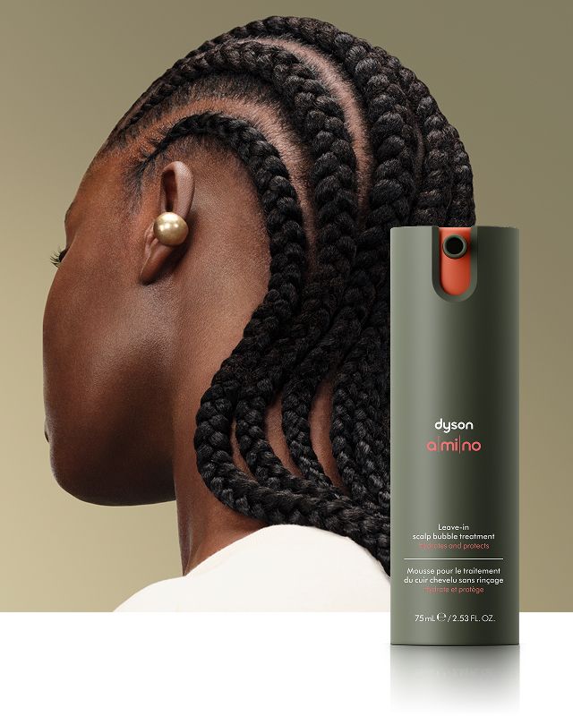 Tratamiento Dyson Amino Espuma leave-in para el cuero cabelludo frente a una modelo con cabello nutrido.