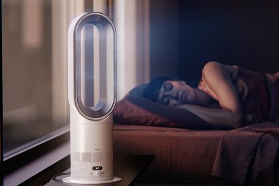 The Dyson Hot+Cool HF1 Remote Link Pre-heat heater and cooling fan operates quietly in a bedroom near a sleeping person.