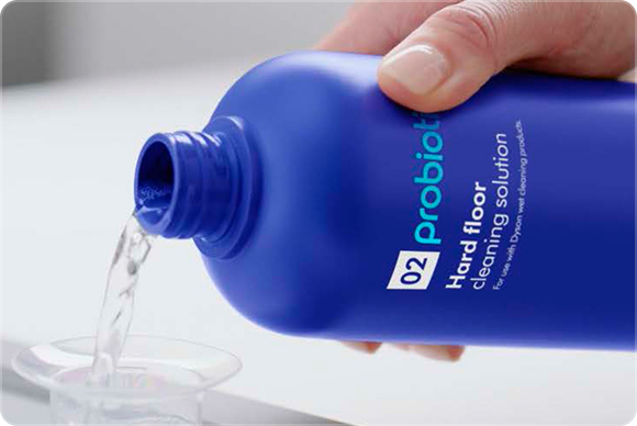 Solución de limpieza para suelos Dyson 02 Probiotic vertida en un vaso medidor.
