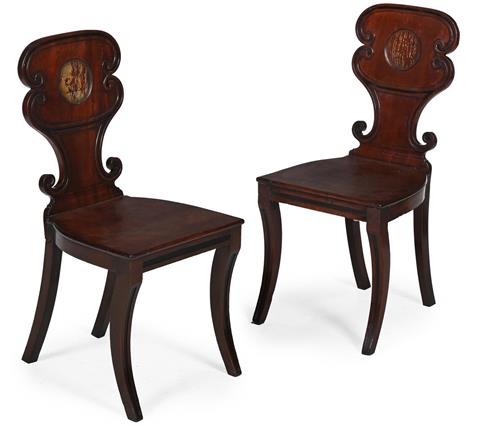 A PAIR OF REGENCY MAHOGANY HALL CHAIRS CIRCA 1820 Each with a cartouche back with vacant armorial and with sabre legs