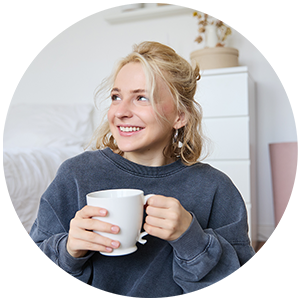 Smiling woman holding a white mug indoors.