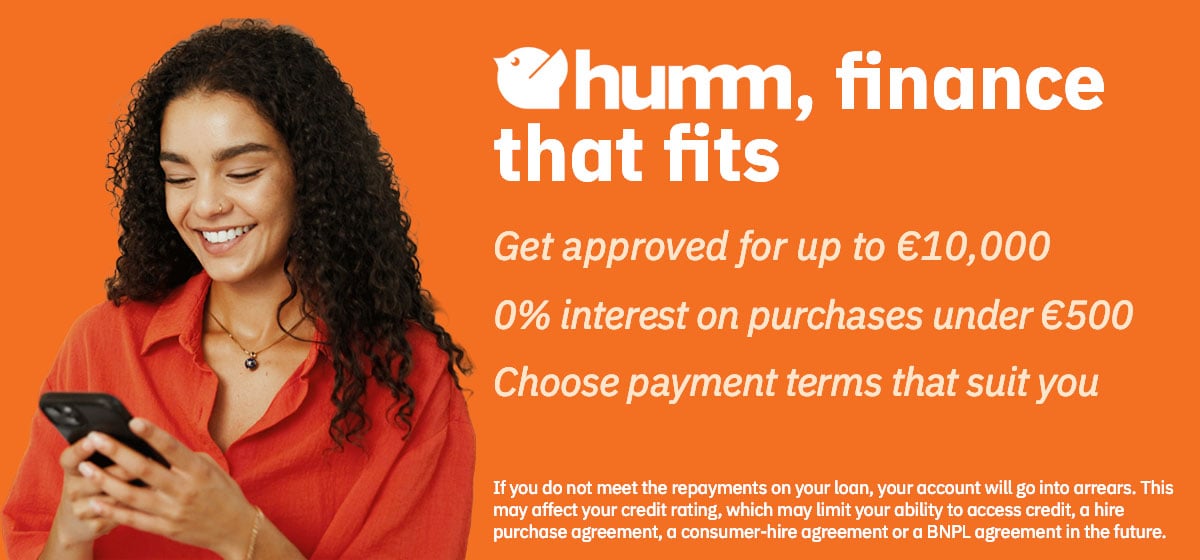 Smiling woman using phone, orange background.