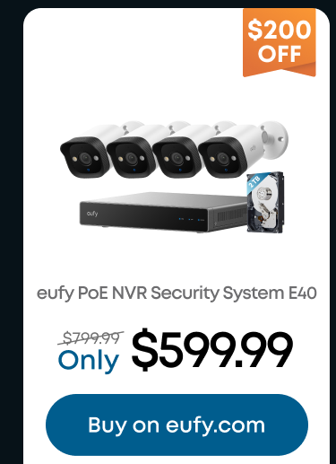 Man in a gray blazer over a dark gray shirt standing on stairs in an urban background.