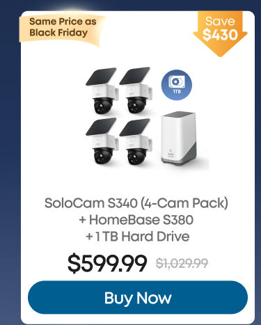 Man in a gray blazer over a dark gray shirt standing on stairs in an urban background.