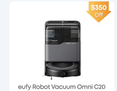 Man in a gray blazer over a dark gray shirt standing on stairs in an urban background.