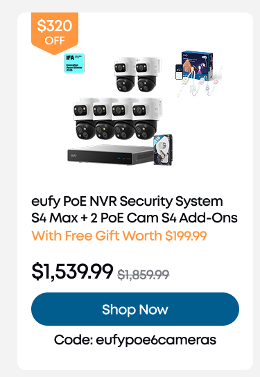 Man in a gray blazer over a dark gray shirt standing on stairs in an urban background.