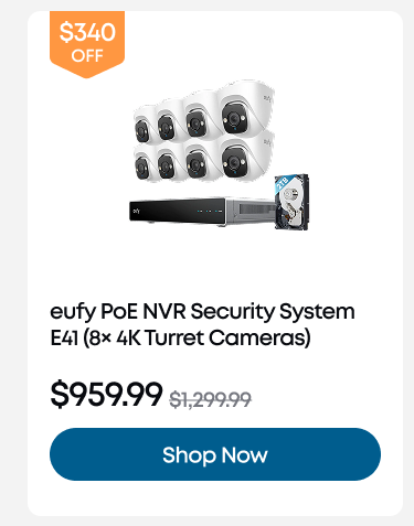 Man in a gray blazer over a dark gray shirt standing on stairs in an urban background.