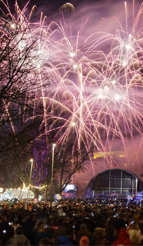 Fogo de artífício à noite numa praça cheia de pessoas