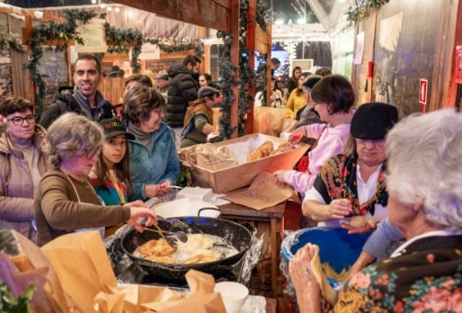 Mercado de Natal com várias senhoras a confeccionar os doces de Natal