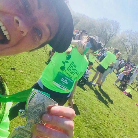 Group of women posing for a photo on muddy obstacle course
