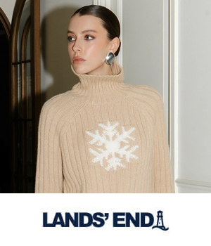 Lands' End - Woman in an elegant beige turtleneck sweater featuring a white snowflake design, wearing large silver earrings.