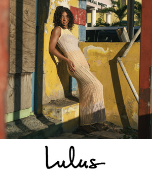 Lulus - Woman in a long, beige crochet dress poses against a weathered yellow wall. Sunlit, tropical setting.