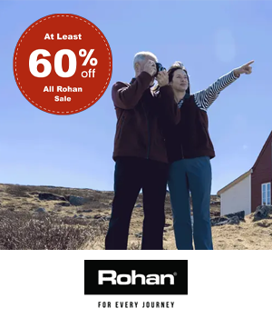 Rohan: Couple looking out over coast through binoculars, sticker reads "At least 60% off All Rohan Sale"