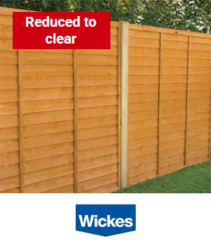Wickes: Fence panels in a garden with sticker reading "Reduced to clear"