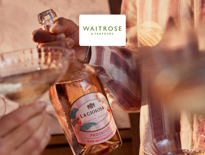 Waitrose & Partners: Woman holding a bottle of prosecco in party setting