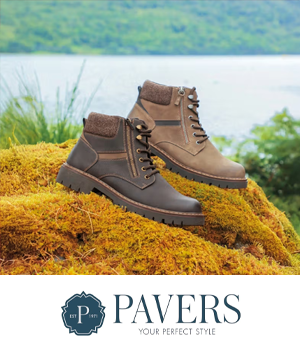 Pavers: Two rugged ankle boots in brown and tan sit on mossy terrain with a serene lake and lush green hills in the background.