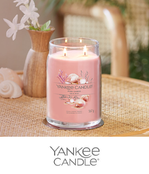Yankee Candle: "Pink Sands" scented candle on a table decorated with seashells