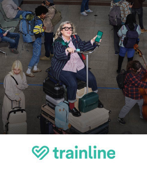 Trainline - Woman sitting on a stack of suitcases, holding a phone with the Trainline app