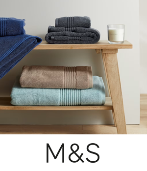 M&S - Coloured bath towels stacked on a wooden rack