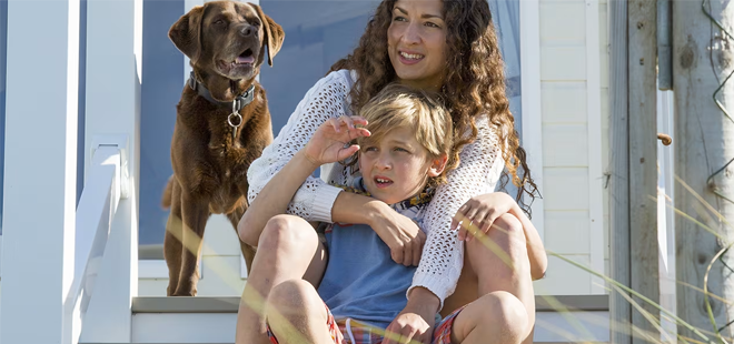 Away Resorts - Mother and son looking at view from holiday park with a dog perched behind them