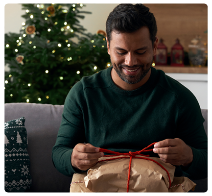 Bild av en man som öppnar en julklapp