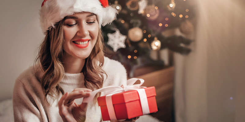 Kvinnan öppnar en röd julklapp