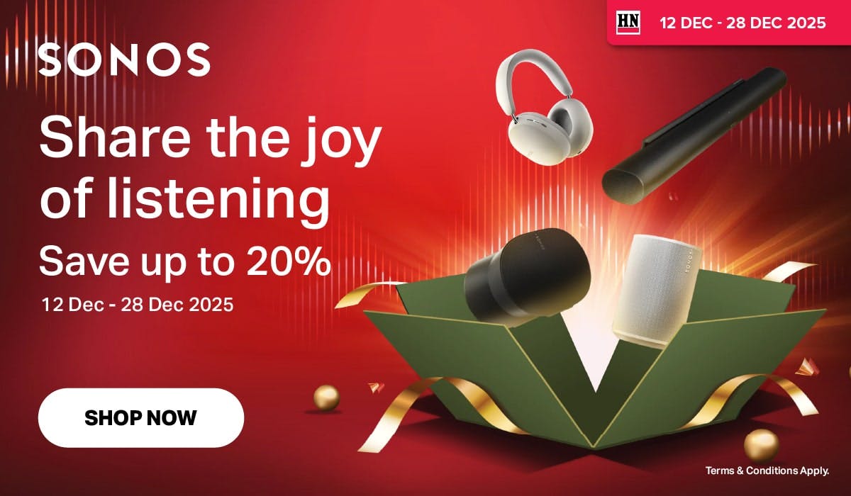 Woman wearing an olive green blazer and light blue jeans walking in an urban setting.