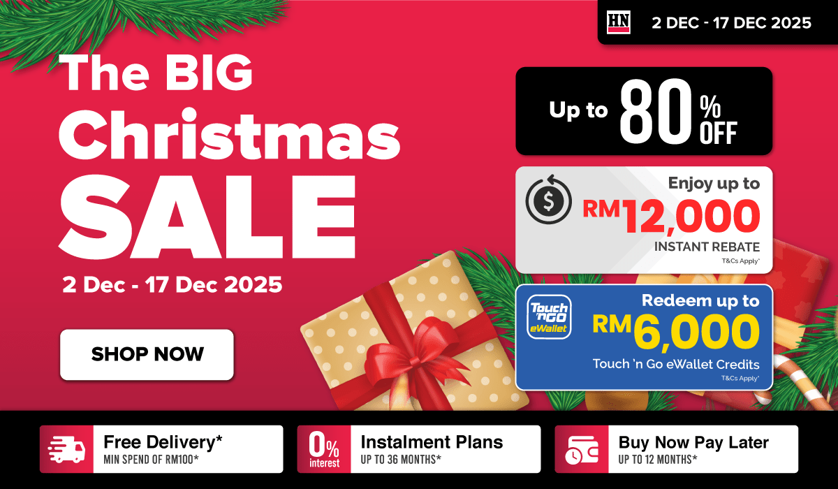 Man in a gray blazer over a dark gray shirt standing on stairs in an urban background.