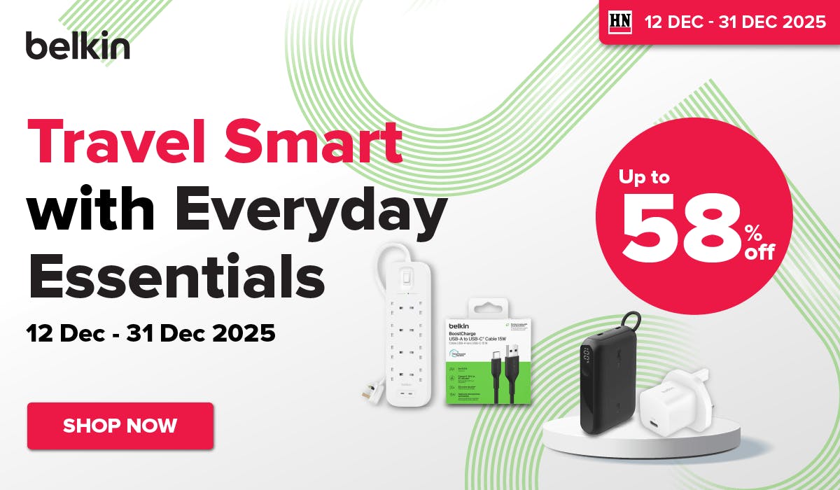 Man in a gray blazer over a dark gray shirt standing on stairs in an urban background.