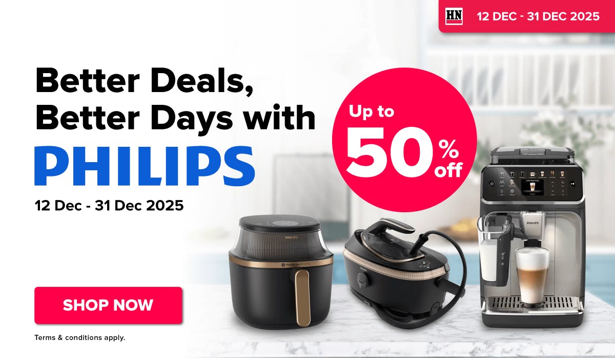 Man in a gray blazer over a dark gray shirt standing on stairs in an urban background.