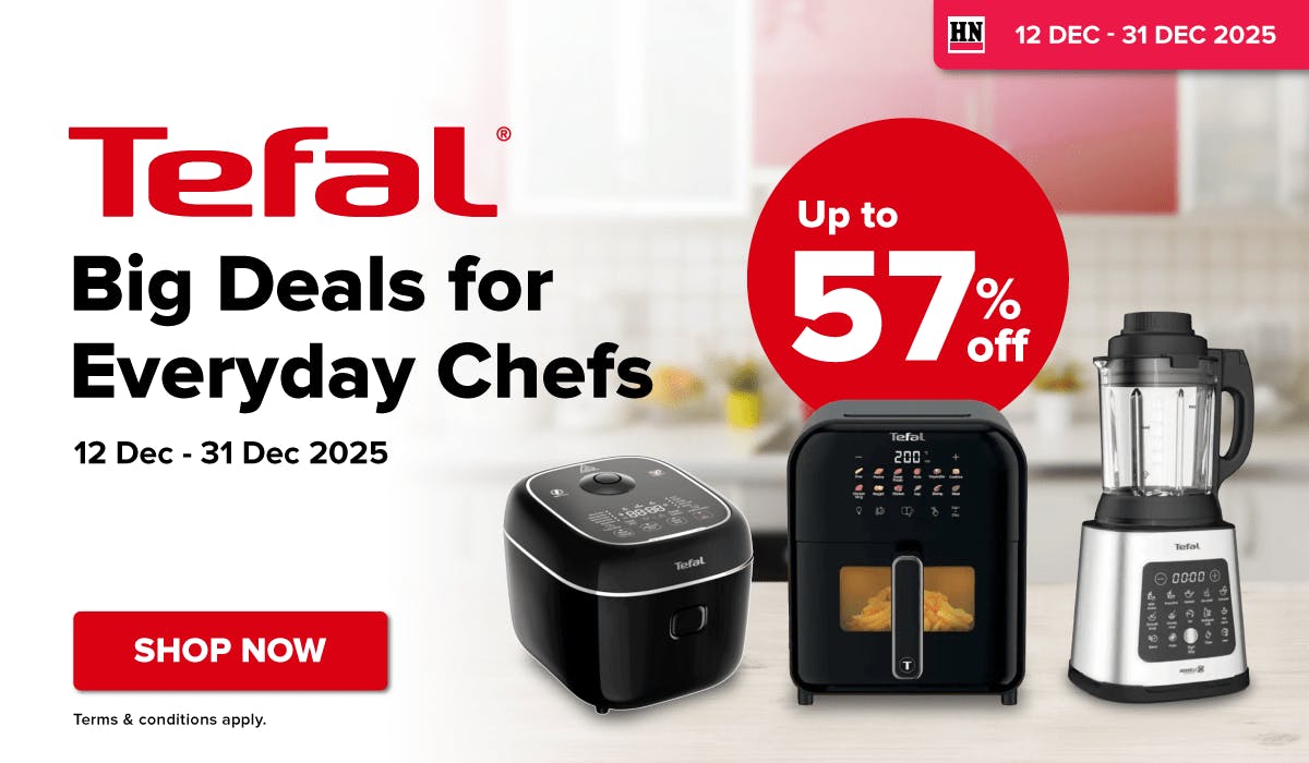 Woman wearing an olive green blazer and light blue jeans walking in an urban setting.