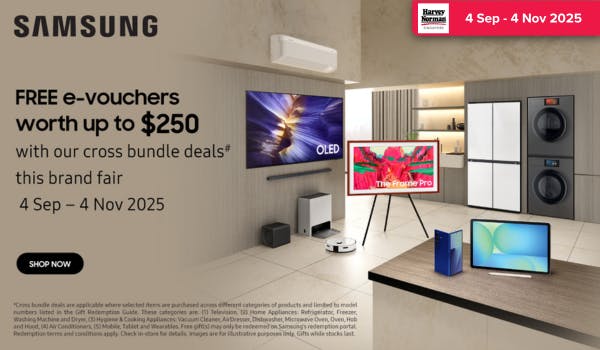 Man in a gray blazer over a dark gray shirt standing on stairs in an urban background.