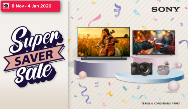 Man in a gray blazer over a dark gray shirt standing on stairs in an urban background.