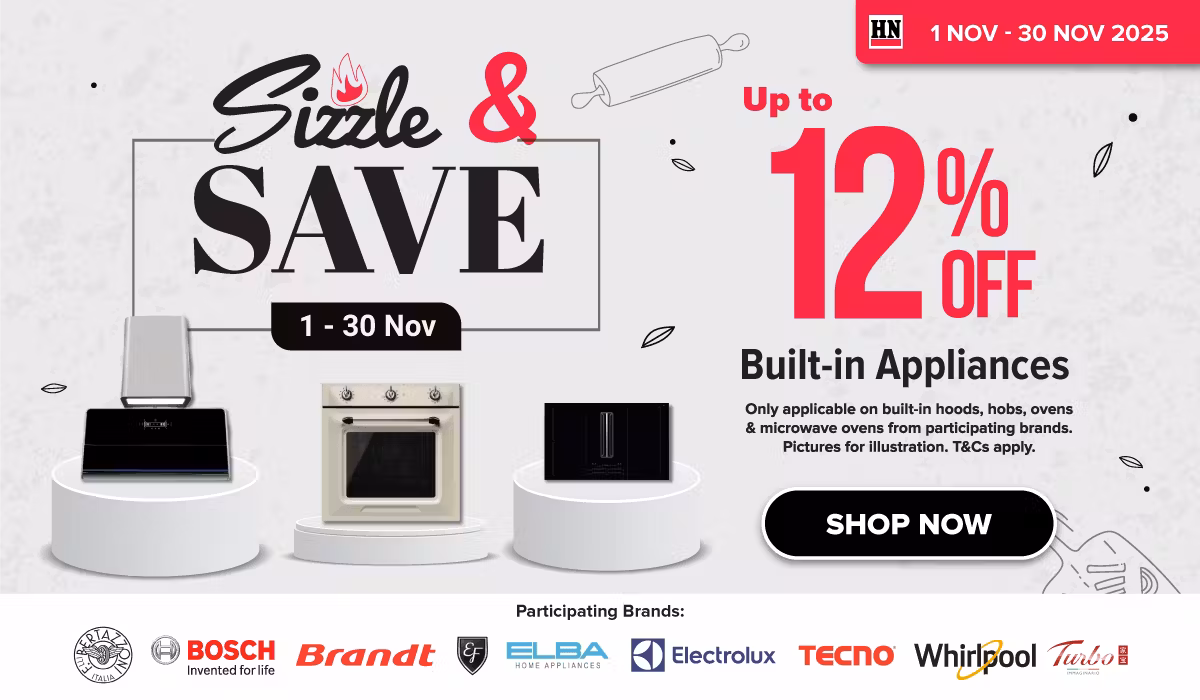 Man in a gray blazer over a dark gray shirt standing on stairs in an urban background.