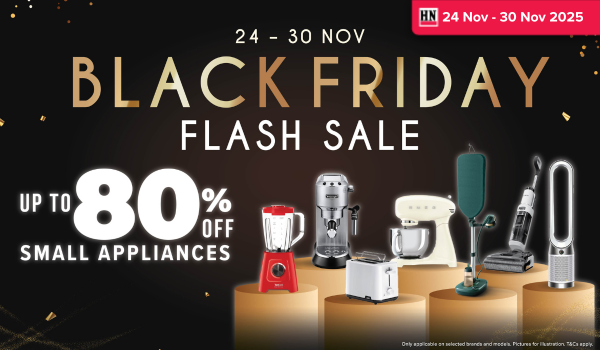 Woman wearing an olive green blazer and light blue jeans walking in an urban setting.