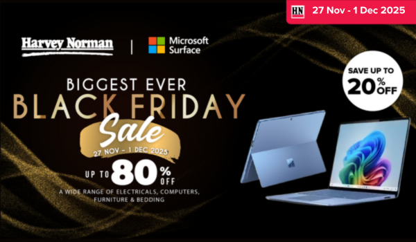 Man in a gray blazer over a dark gray shirt standing on stairs in an urban background.