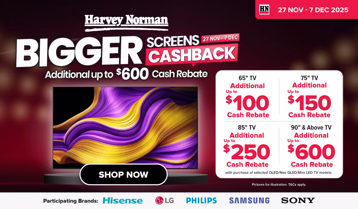 Man in a gray blazer over a dark gray shirt standing on stairs in an urban background.