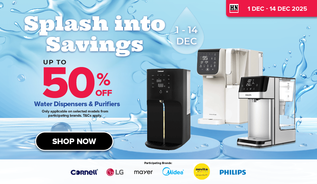 Woman wearing an olive green blazer and light blue jeans walking in an urban setting.